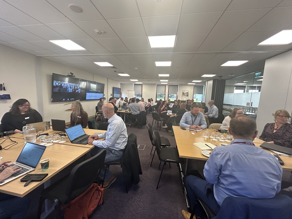 Photo taken at a Challenging Poverty Stakeholder event held at Colleges Scotland. The image shows a number of people sitting at tables in discussion.
