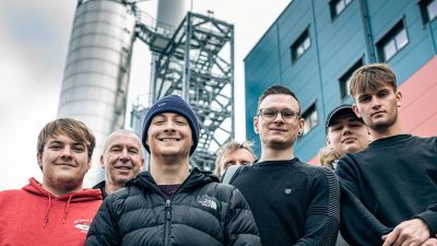 A group of people standing in front of a industry building
